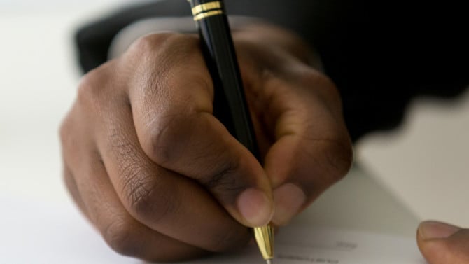 Man writing  regulatory compliance contract.