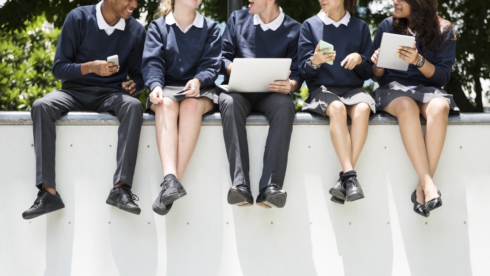 Students sitting on wall