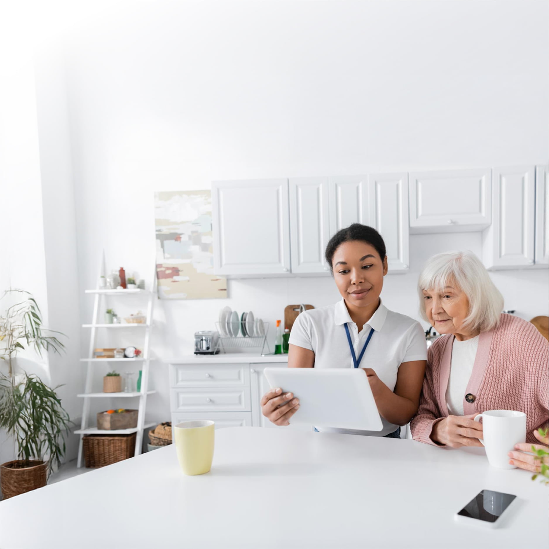 A healthcare provider and elderly woman looking at a tablet together