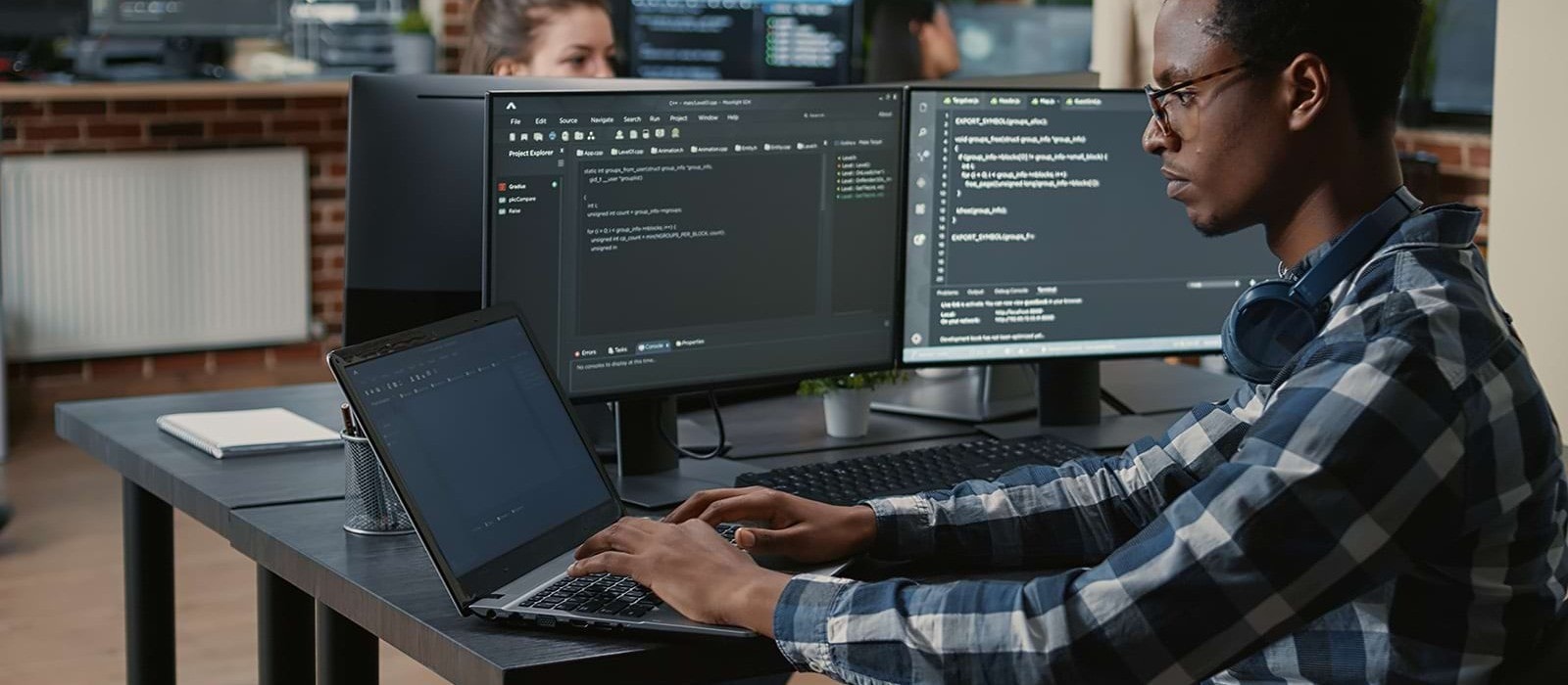 man staring at multiple pc intensely coding