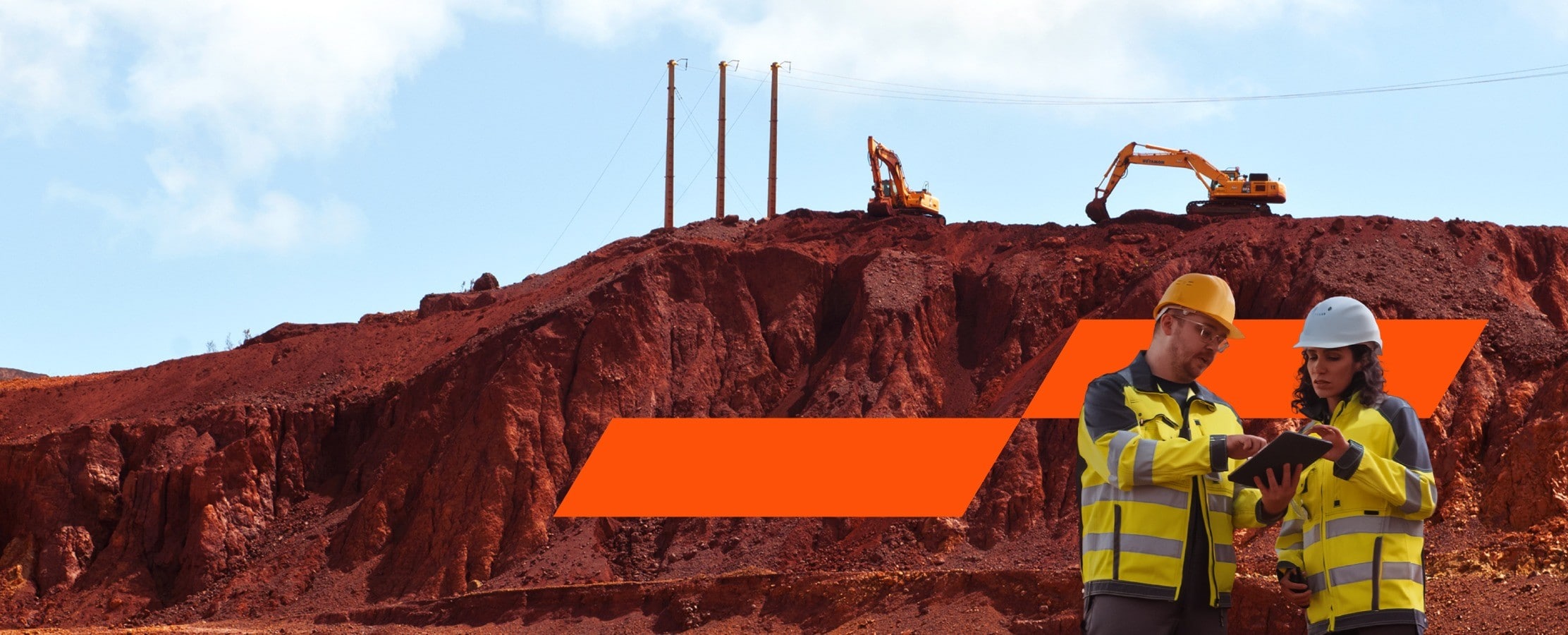 two miners looking at a tablet at a mining site