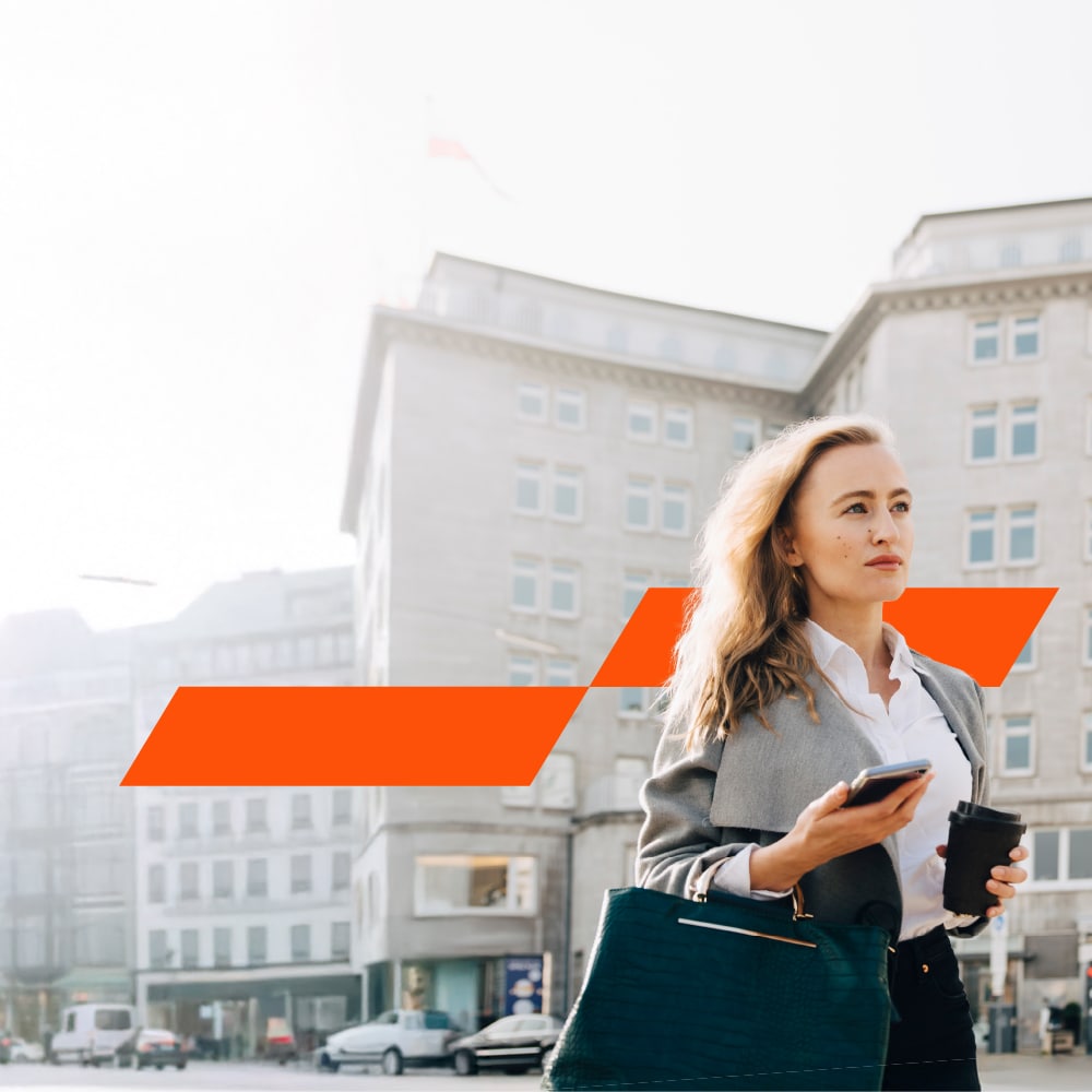 Office lady walking down the street holding coffee and mobile phone