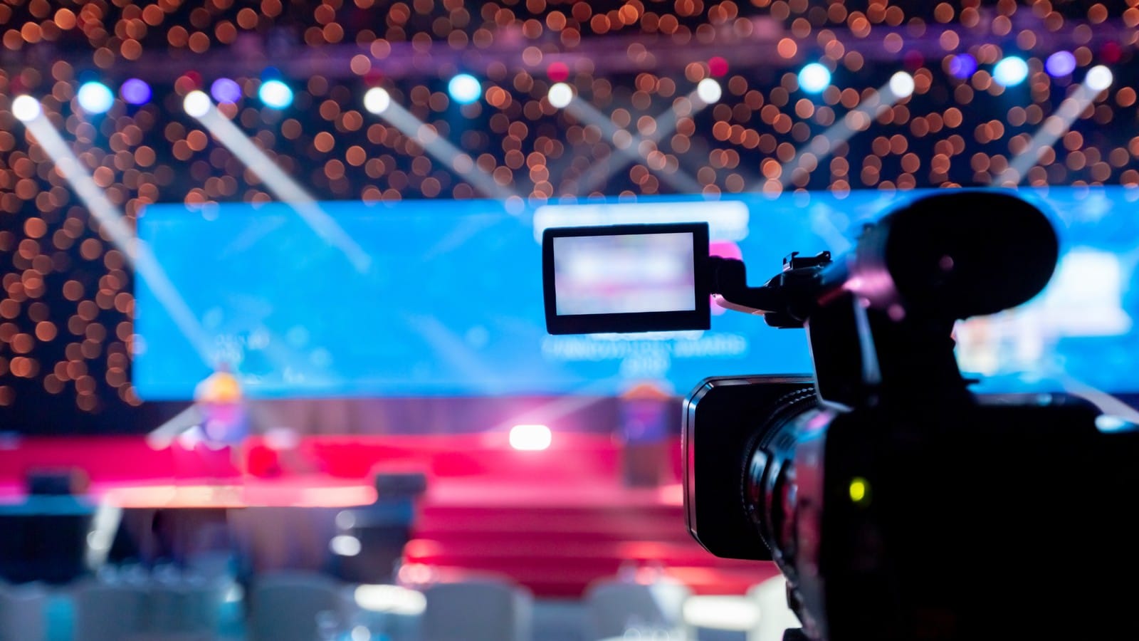 Camera filming people on stage