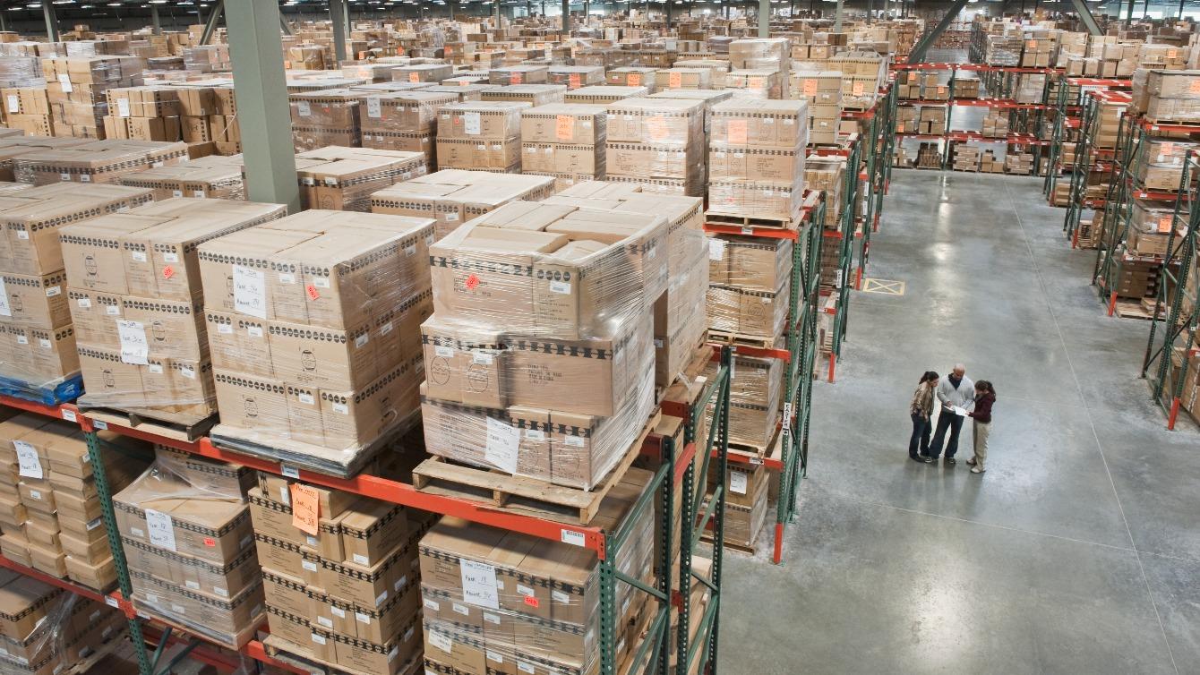 Group of workers in a full warehouse looking at orders