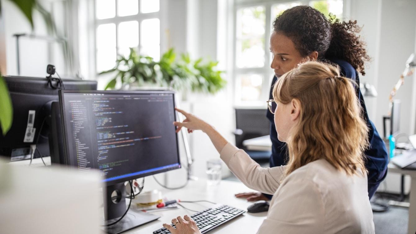 Two women working on software in the office